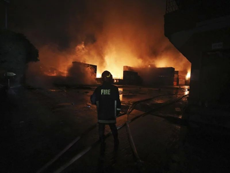 A firefighter works to contain a fire that broke out at the BM Inland Container Depot, a Dutch-Bangladesh joint venture, in Chittagong, 216 kilometers (134 miles) southeast of capital, Dhaka, Bangladesh, early Sunday, June 5, 2022. Several people were killed and more than 100 others were injured in the fire the cause of which could not be immediately determined. (AP Photo)